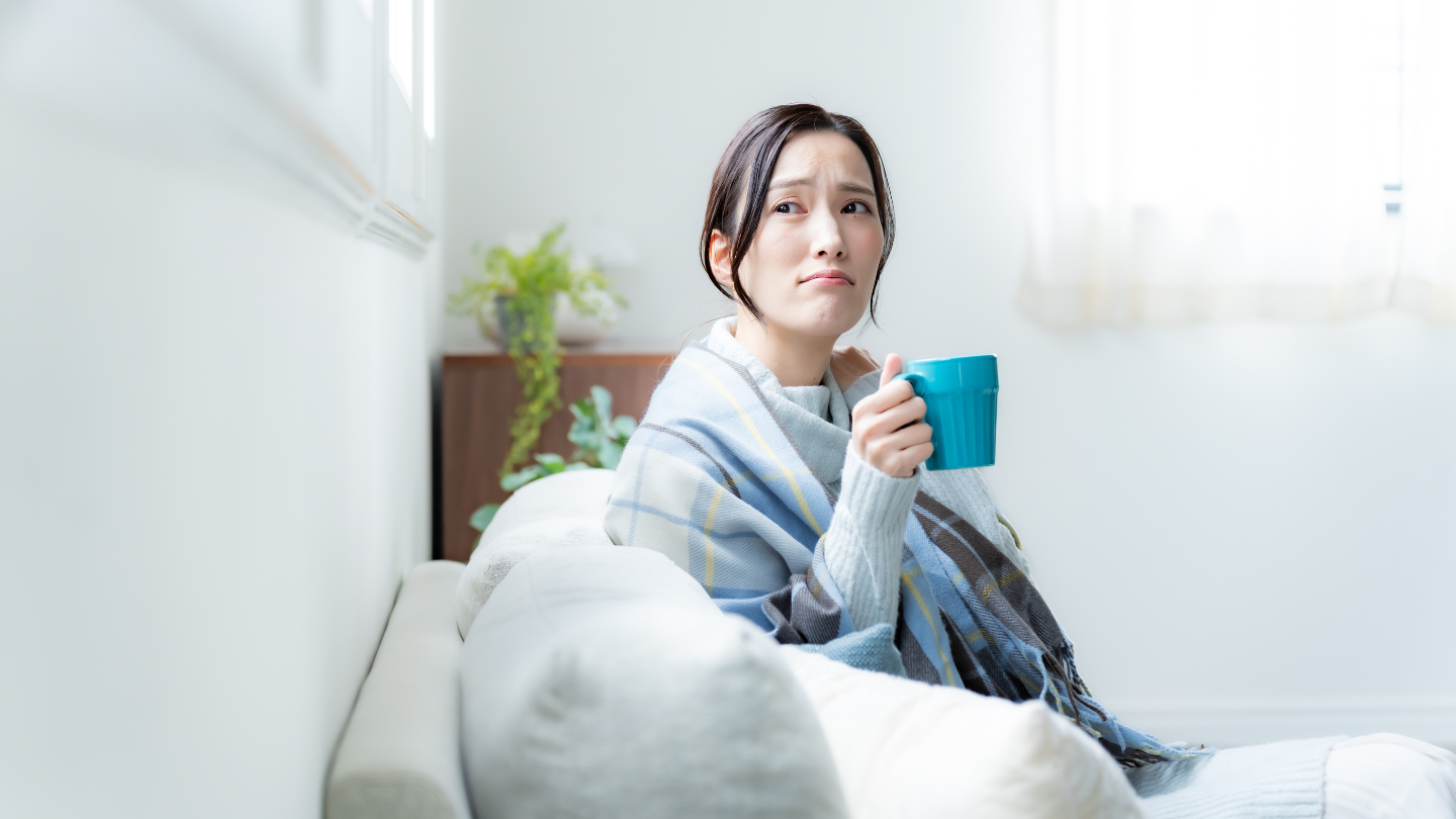 Receptor judicial. Mujer senada en el sofá, tomando té, con cara de preocupada